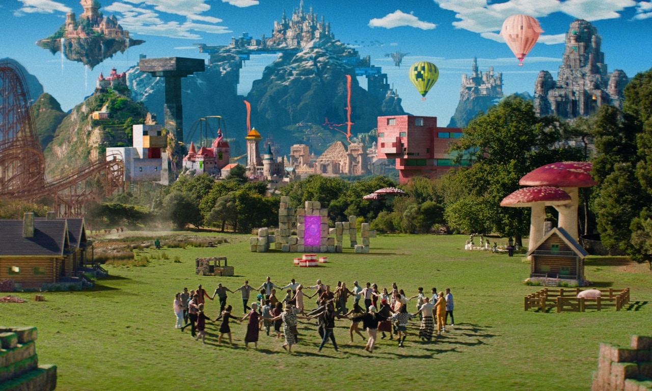 An image showing people dancing in a circle holding hands in a field. In the background, there are various blocky builds, including a giant chicken, a giant pig, and islands in the sky with castles on them. Throughout the image there are more whimsical elements like giant mushrooms, Minecraft-themed hot air balloons, and a rollercoaster.